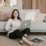Cheerful woman using laptop at home